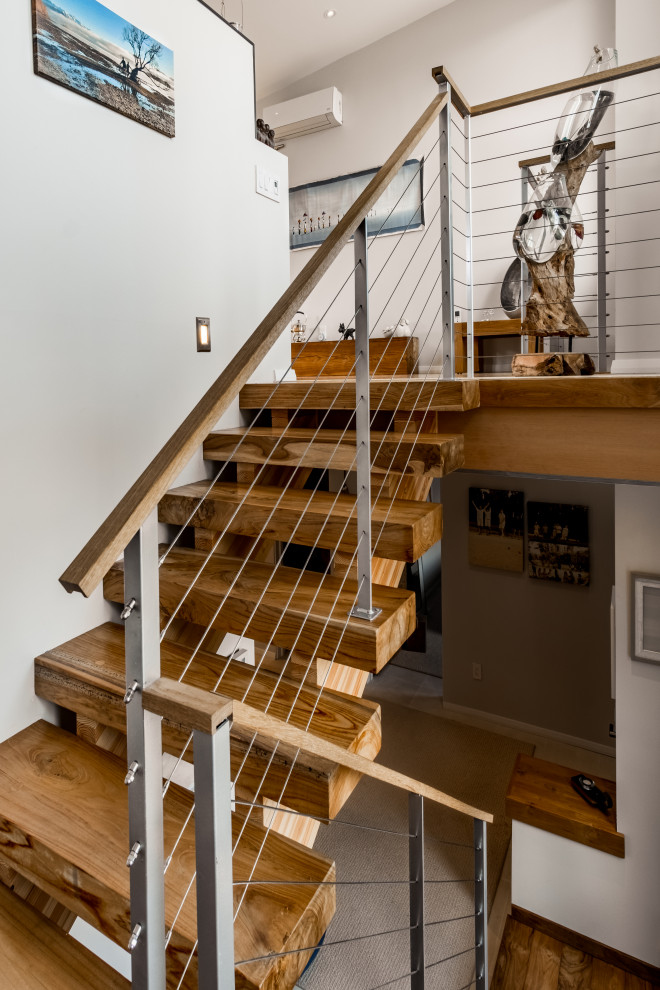 Ejemplo de escalera en U moderna de tamaño medio sin contrahuella con escalones de madera y barandilla de cable