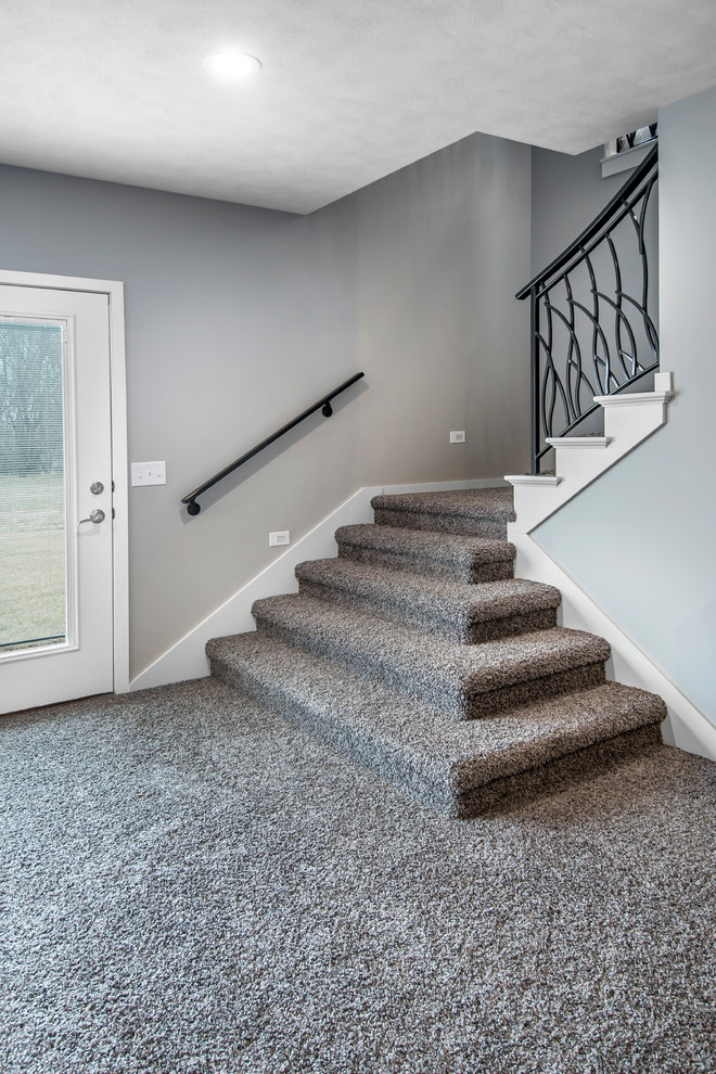 Inspiration for a mid-sized transitional carpeted l-shaped metal railing staircase remodel in Omaha with carpeted risers