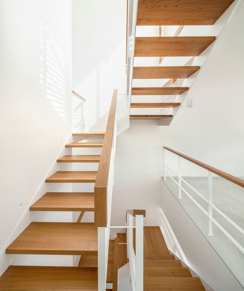 Medium sized contemporary wood u-shaped staircase in Barcelona with open risers.