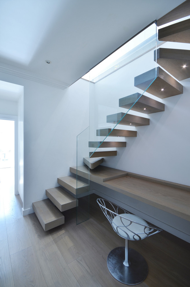 Diseño de escalera en L actual pequeña sin contrahuella con escalones de madera y barandilla de vidrio
