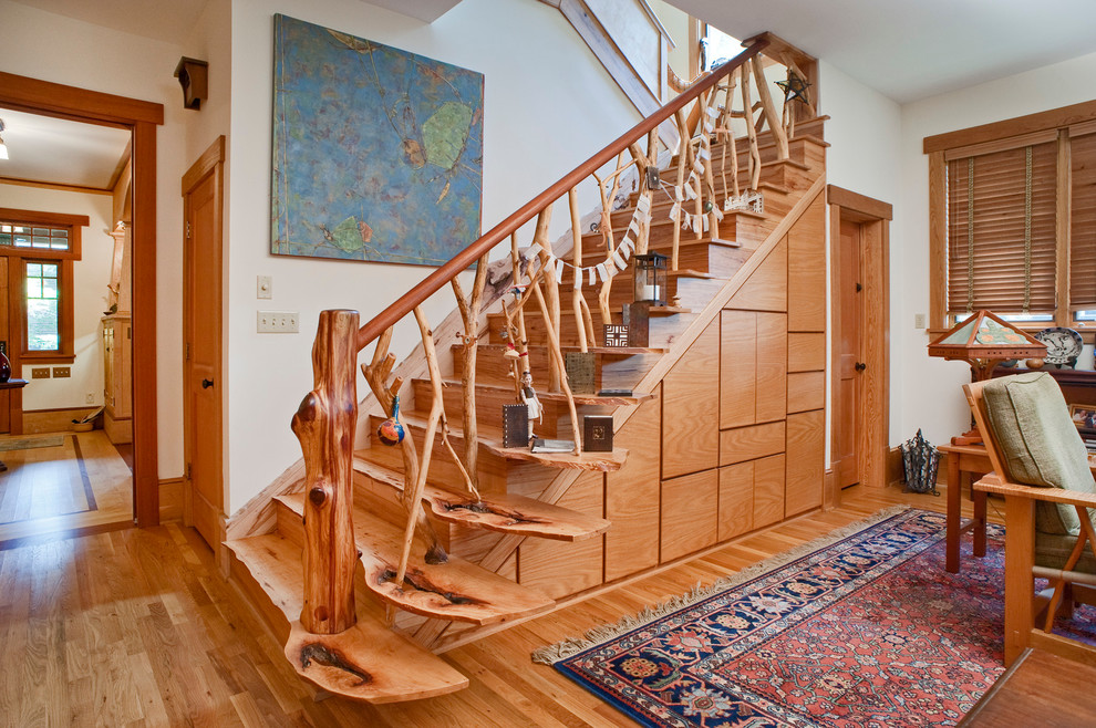 На фото: винтовая деревянная лестница среднего размера в стиле кантри с деревянными ступенями и деревянными перилами с