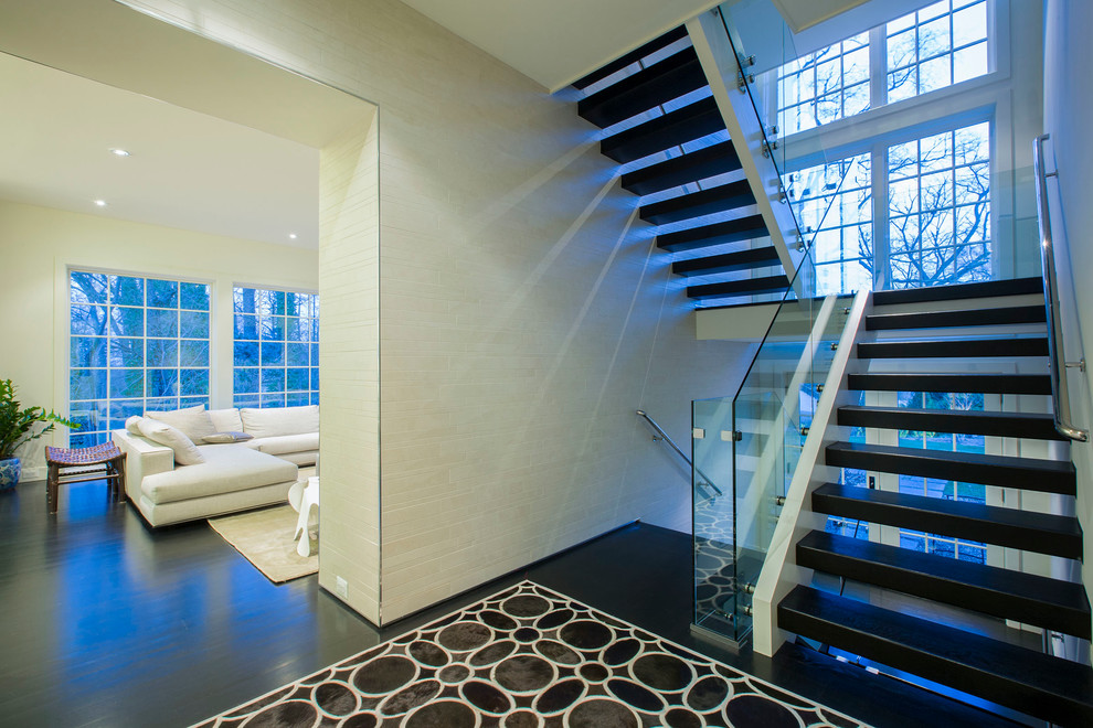Cette image montre un grand escalier sans contremarche minimaliste en U avec des marches en bois.