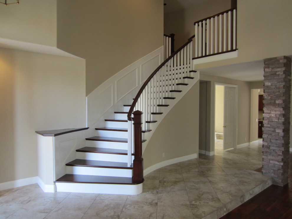 Cette photo montre un grand escalier peint courbe craftsman avec des marches en bois.