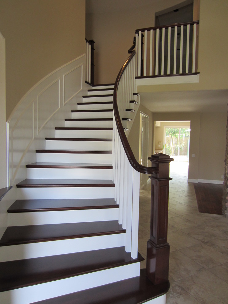 Design ideas for a large classic wood curved staircase in Orange County with painted wood risers.