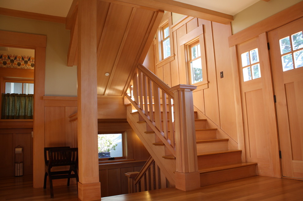 Idée de décoration pour un grand escalier craftsman en U avec des marches en bois, des contremarches en bois et un garde-corps en bois.