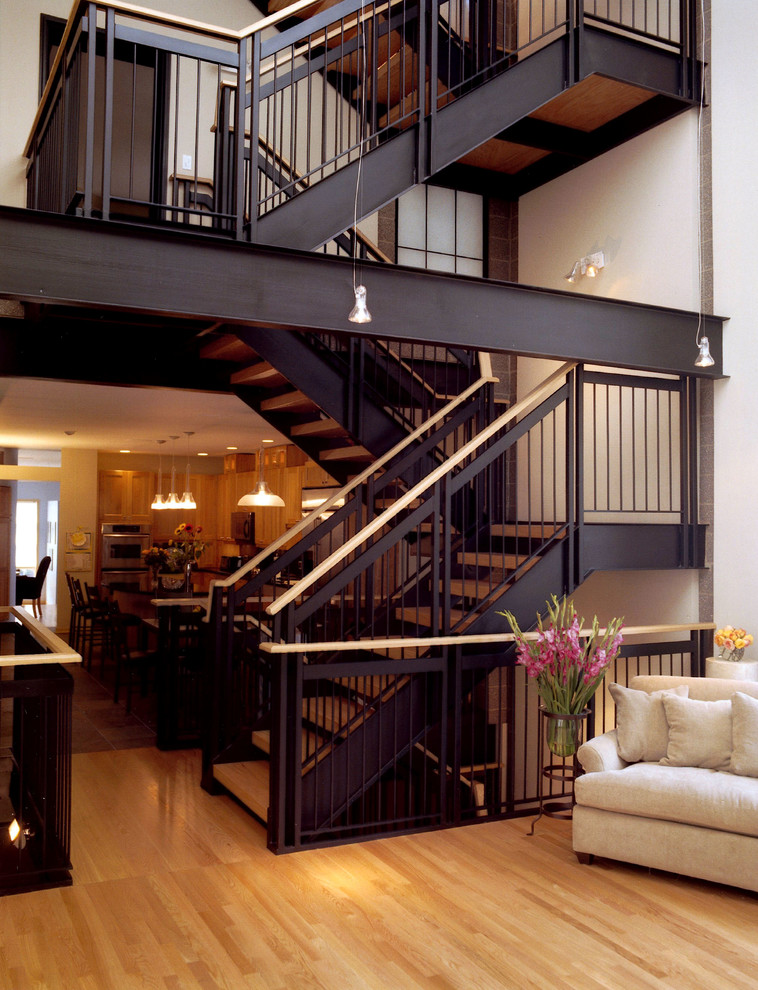 На фото: огромная угловая лестница в стиле модернизм с деревянными ступенями без подступенок