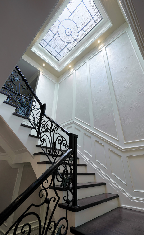 Idées déco pour un grand escalier peint classique en U avec des marches en bois et un garde-corps en métal.