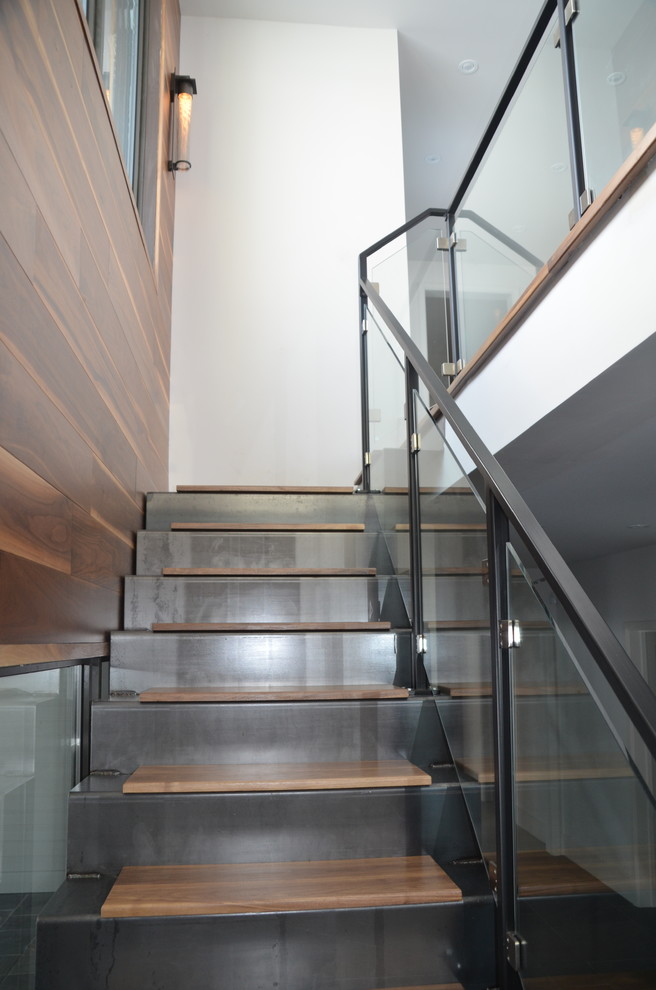 Réalisation d'un escalier flottant design avec des marches en bois et des contremarches en métal.