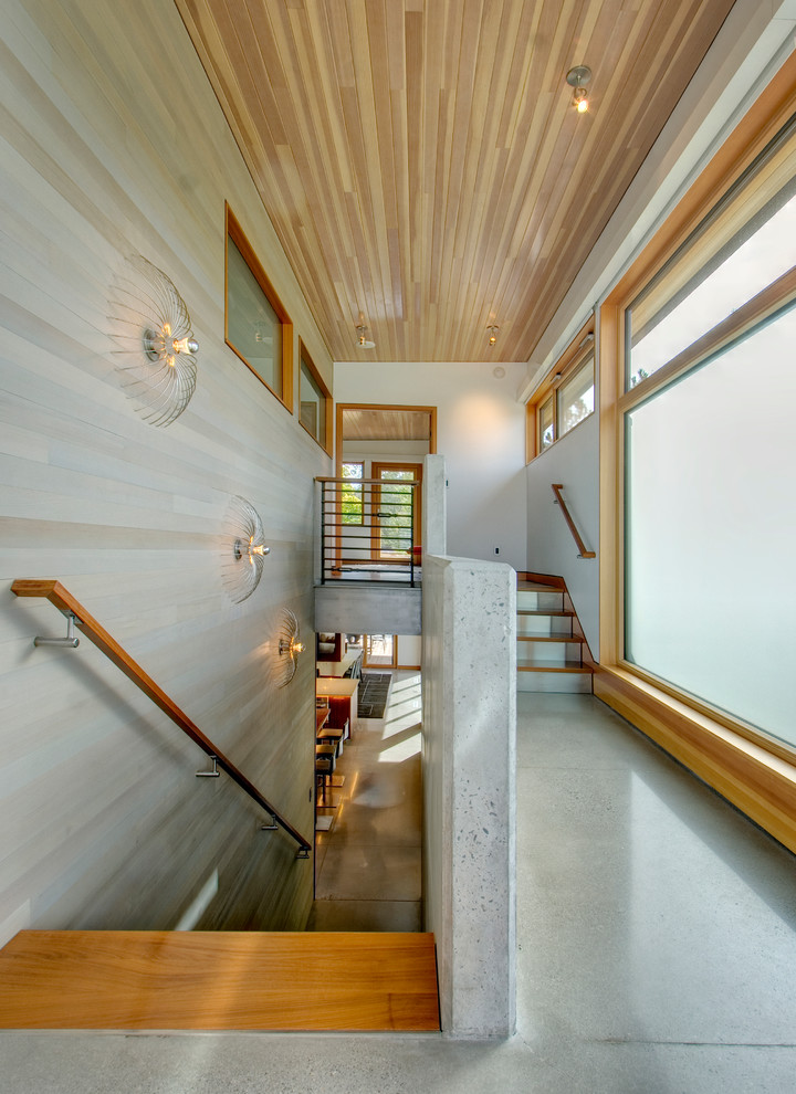 This is an example of a medium sized contemporary wood u-shaped staircase in Seattle with concrete risers.