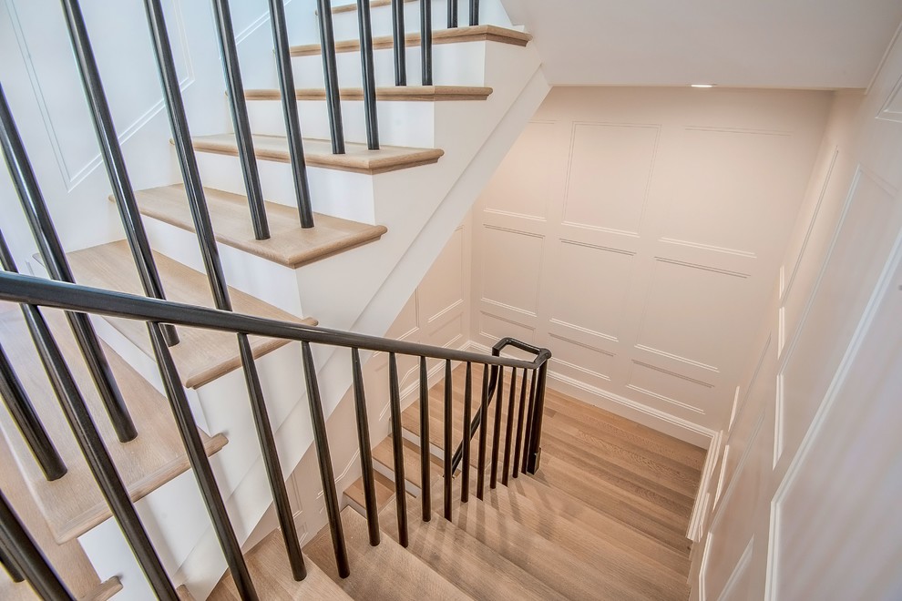 Example of a large transitional wooden u-shaped staircase design in Los Angeles with wooden risers