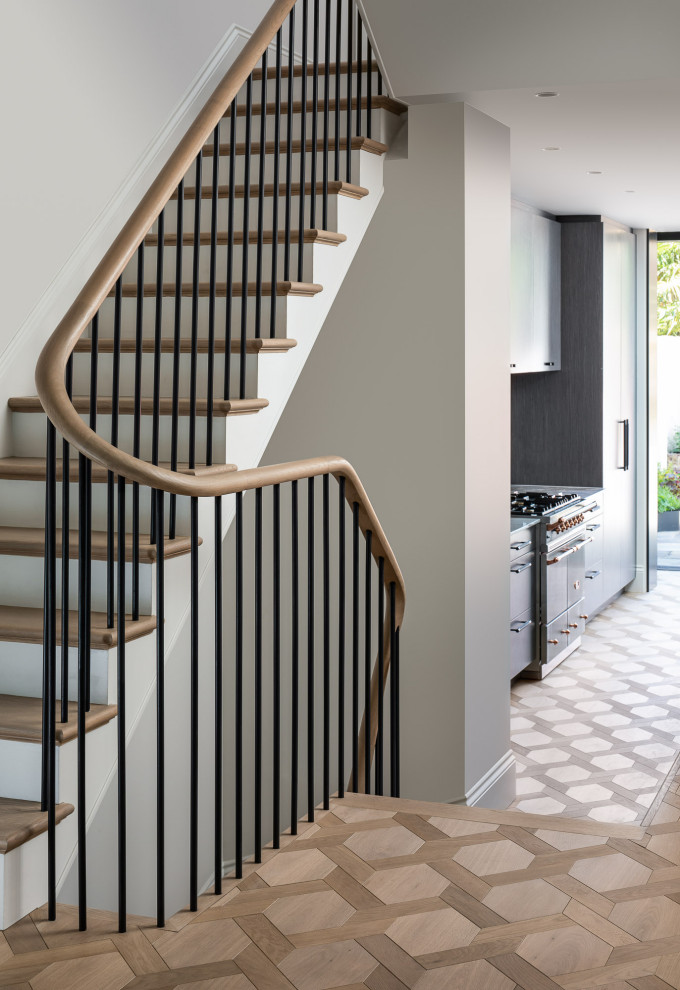 Inspiration for a large contemporary wood u-shaped wood railing staircase in London with painted wood risers.