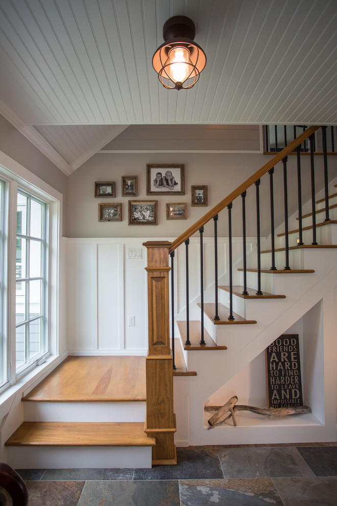 Foto de escalera en L con escalones de madera, contrahuellas de madera y barandilla de varios materiales