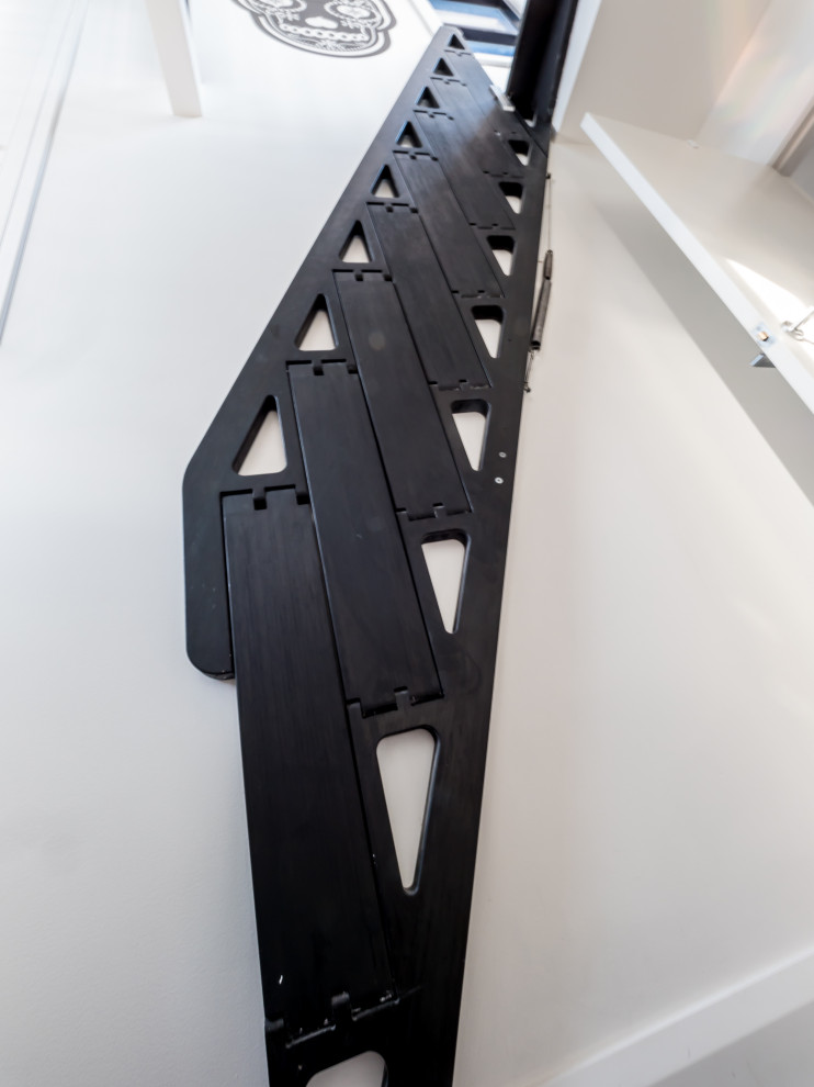 Immagine di una piccola scala a rampa dritta minimal con pedata in legno verniciato, alzata in legno verniciato e parapetto in legno