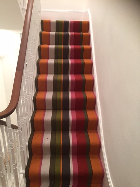 Photo of a medium sized modern carpeted u-shaped wood railing staircase in London with carpeted risers.