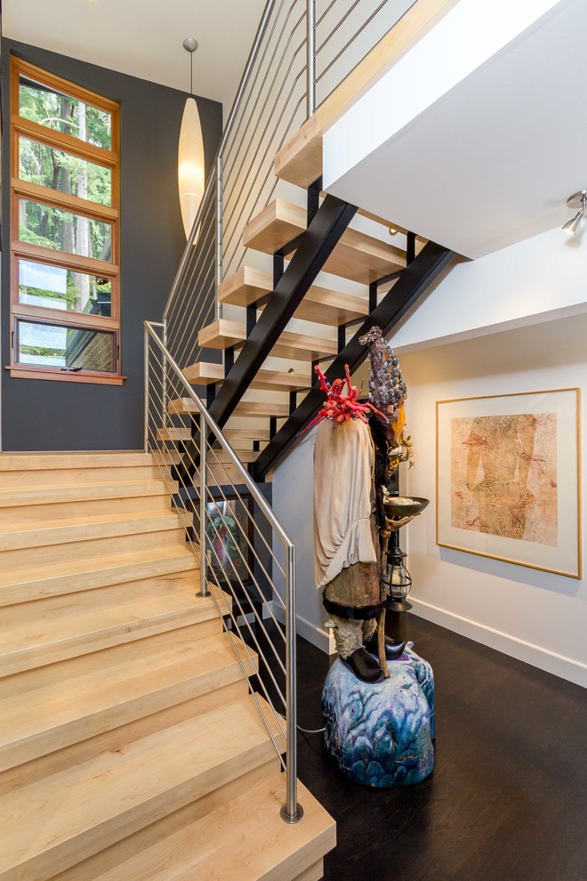На фото: металлическая лестница в стиле модернизм с деревянными ступенями и металлическими перилами с