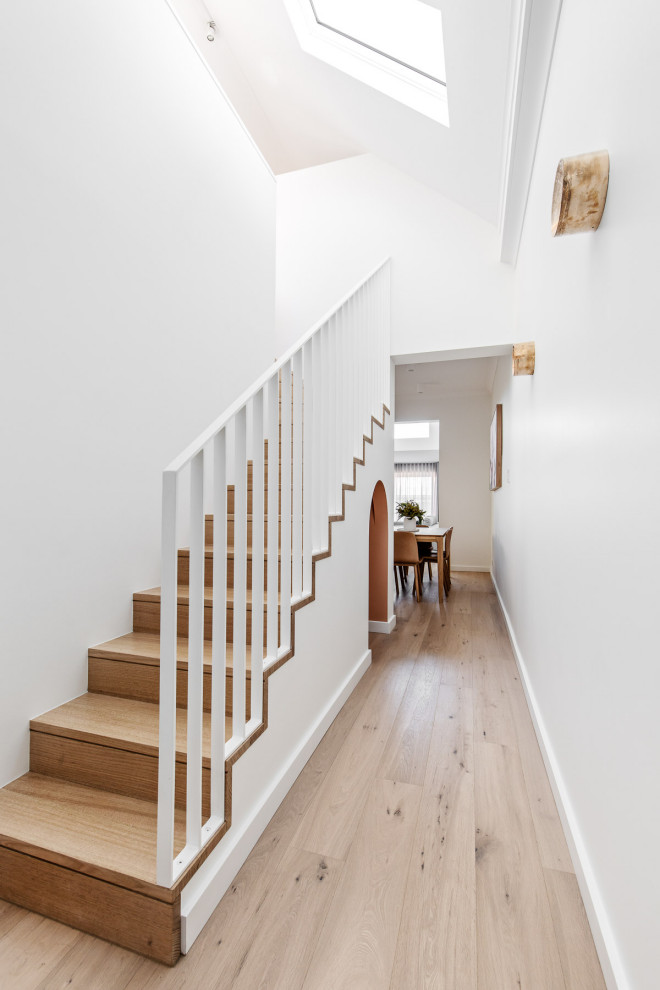 Diseño de escalera en L contemporánea pequeña con escalones de madera, contrahuellas de madera y barandilla de metal