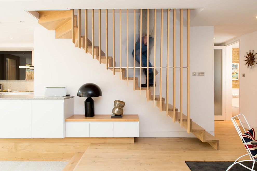 Inspiration for a scandinavian wood l-shaped staircase in London with wood risers and feature lighting.