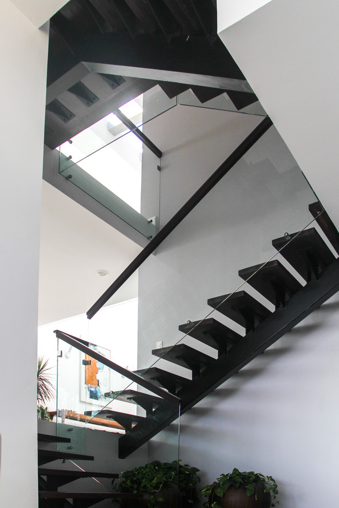 他の地域にあるラグジュアリーな巨大なコンテンポラリースタイルのおしゃれな折り返し階段 (金属の蹴込み板) の写真