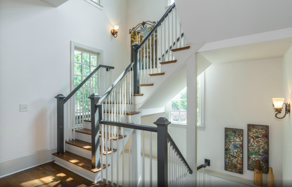 Ejemplo de escalera en U de estilo americano grande con escalones de madera y contrahuellas de madera pintada