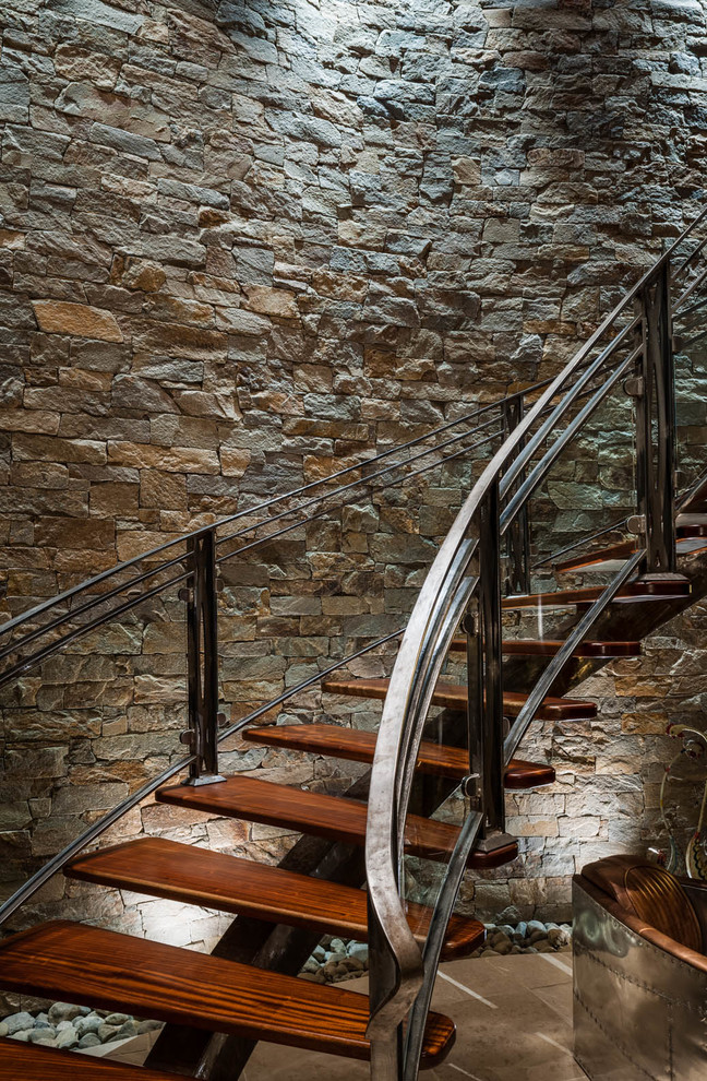 Foto de escalera curva actual grande sin contrahuella con escalones de madera y barandilla de varios materiales