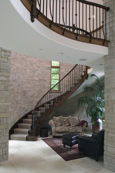 Пример оригинального дизайна: огромная изогнутая деревянная лестница в классическом стиле с деревянными ступенями