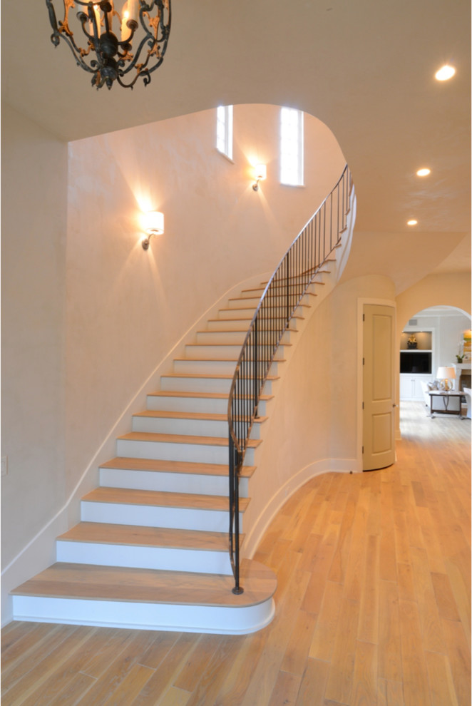 Inspiration pour un grand escalier peint courbe design avec des marches en bois.