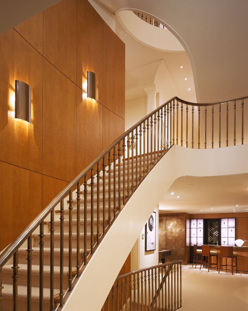Свежая идея для дизайна: большая изогнутая деревянная лестница в стиле неоклассика (современная классика) с деревянными ступенями - отличное фото интерьера