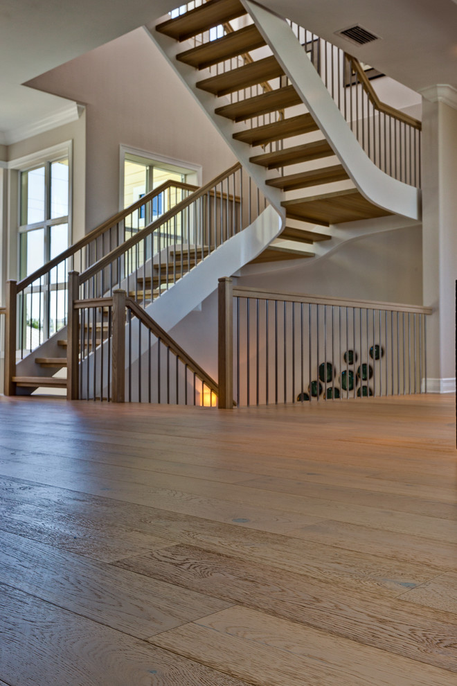 Idée de décoration pour un grand escalier sans contremarche courbe marin avec des marches en bois.