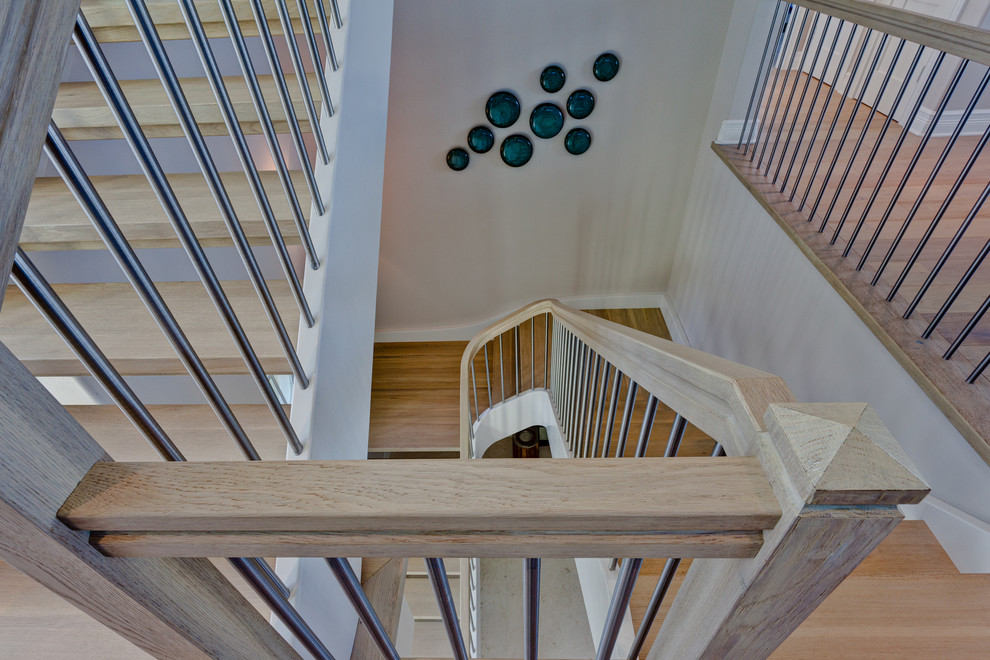 Идея дизайна: большая изогнутая лестница в морском стиле с деревянными ступенями без подступенок