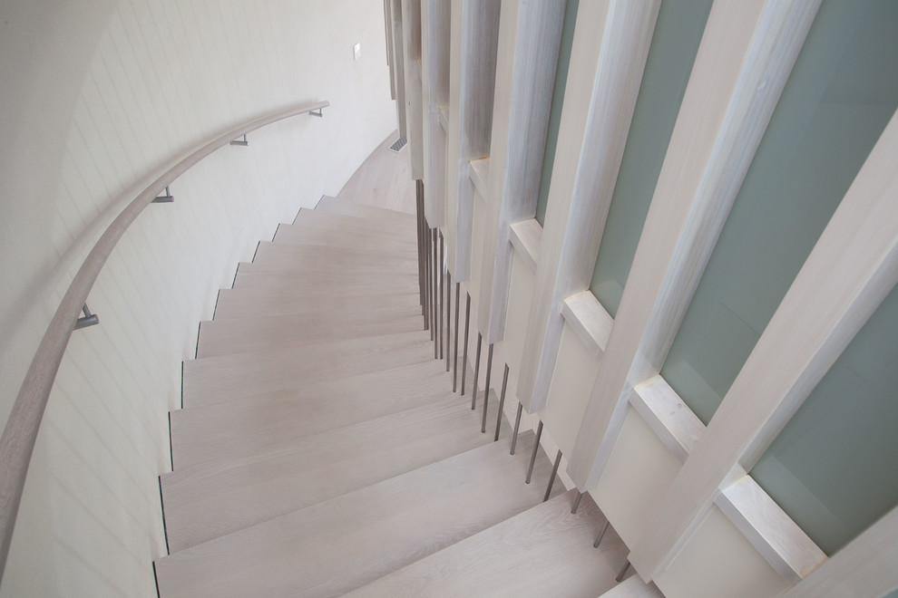 Источник вдохновения для домашнего уюта: большая изогнутая лестница в стиле неоклассика (современная классика) с деревянными ступенями без подступенок