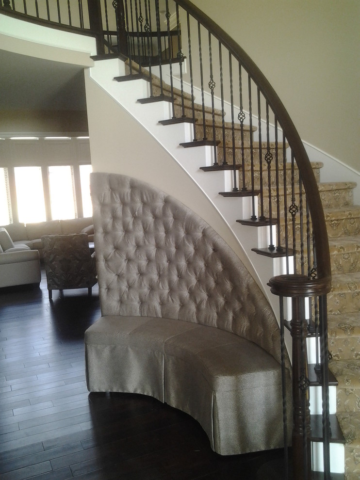 На фото: изогнутая лестница среднего размера в классическом стиле с ступенями с ковровым покрытием, ковровыми подступенками и перилами из смешанных материалов с