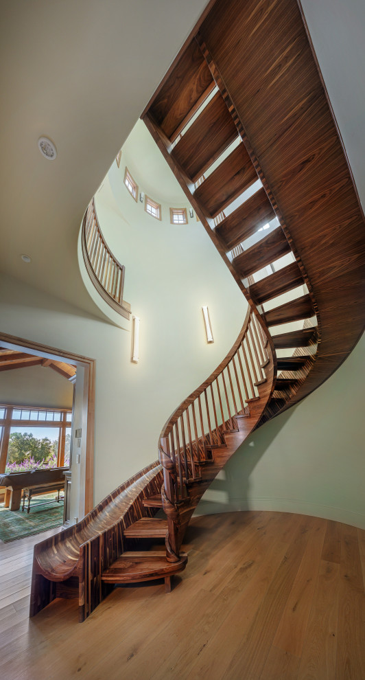 Huge eclectic wooden curved open and wood railing staircase photo in Sacramento