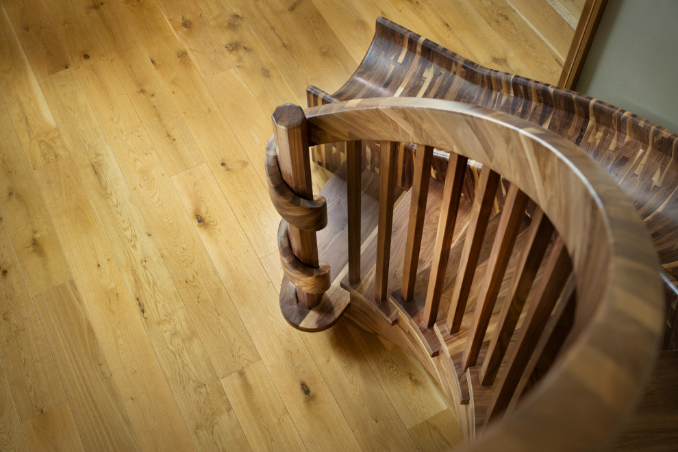 Foto på en mycket stor eklektisk svängd trappa i trä, med öppna sättsteg och räcke i trä