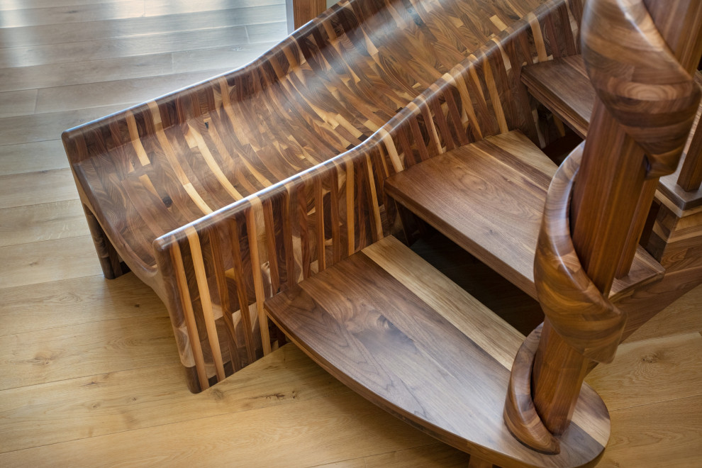 Foto de escalera curva ecléctica extra grande sin contrahuella con escalones de madera y barandilla de madera