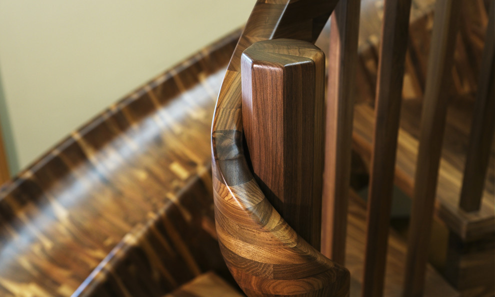 Пример оригинального дизайна: огромная изогнутая лестница в стиле фьюжн с деревянными ступенями и деревянными перилами без подступенок