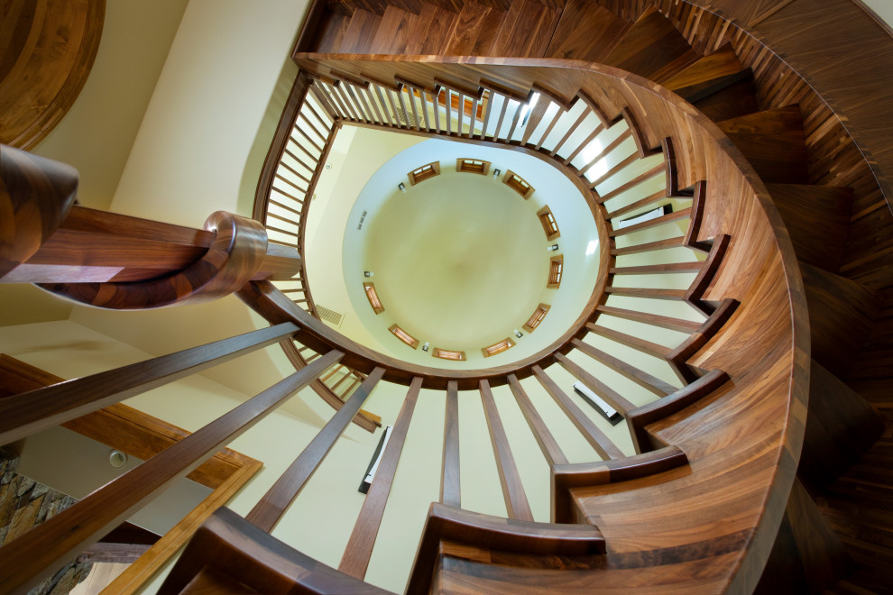Foto de escalera curva bohemia extra grande sin contrahuella con escalones de madera y barandilla de madera
