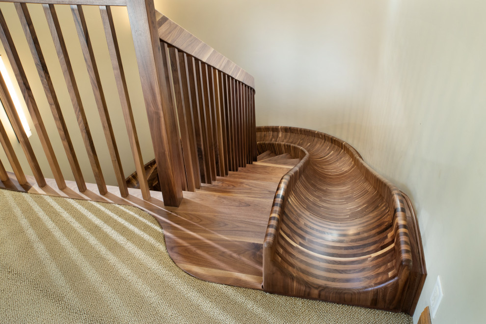 Imagen de escalera curva ecléctica extra grande sin contrahuella con escalones de madera y barandilla de madera