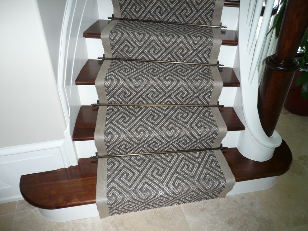 Ejemplo de escalera curva clásica de tamaño medio con escalones de madera y contrahuellas de madera pintada