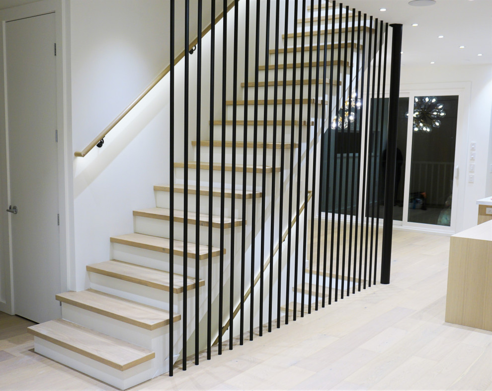 На фото: прямая лестница среднего размера в стиле модернизм с деревянными ступенями, крашенными деревянными подступенками и перилами из смешанных материалов с