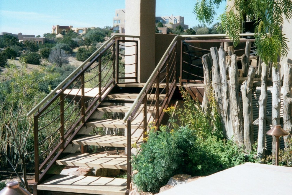 Imagen de escalera recta minimalista con escalones de metal, contrahuellas de metal y barandilla de metal