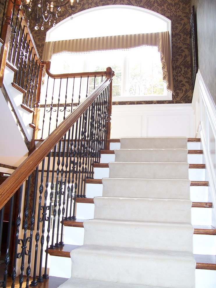Ejemplo de escalera curva tradicional grande con escalones enmoquetados y contrahuellas de madera pintada