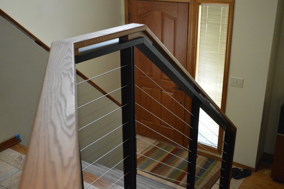 Example of a minimalist wooden metal railing staircase design in Seattle with carpeted risers