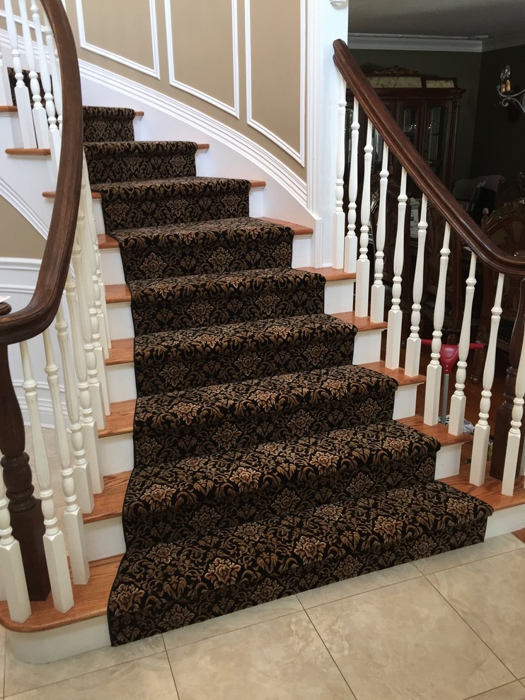 Staircase - mid-sized traditional wooden curved staircase idea in New York with carpeted risers