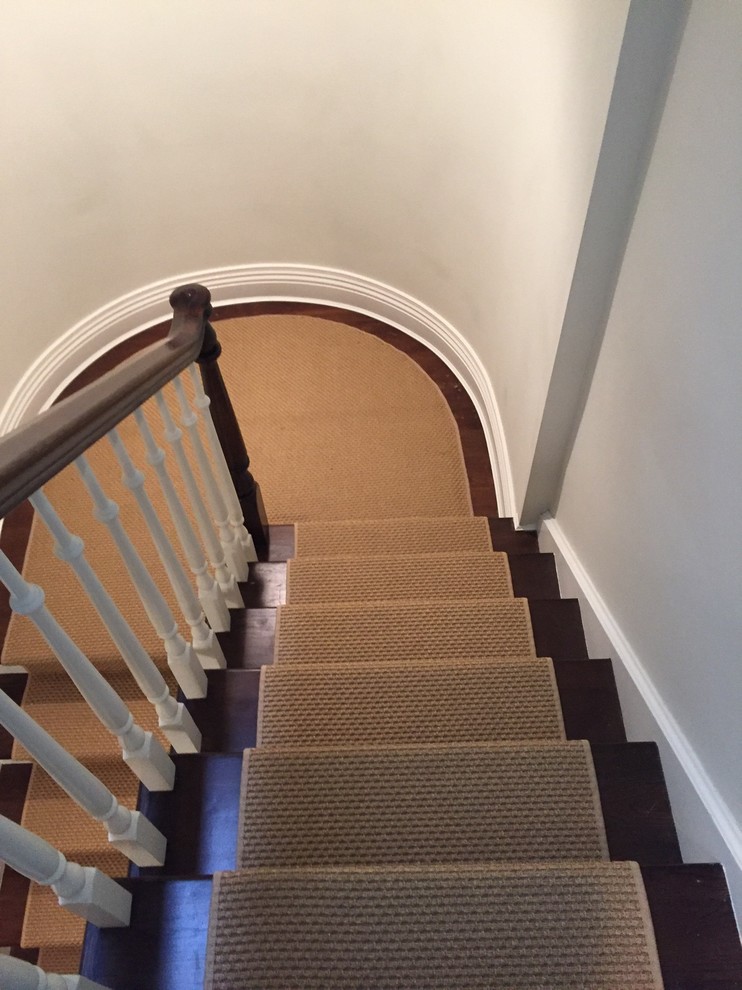 Cette image montre un escalier courbe traditionnel de taille moyenne avec des marches en bois et des contremarches en moquette.