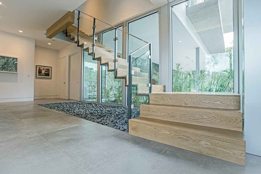 Modelo de escalera suspendida moderna de tamaño medio con escalones de madera, contrahuellas de madera y barandilla de vidrio