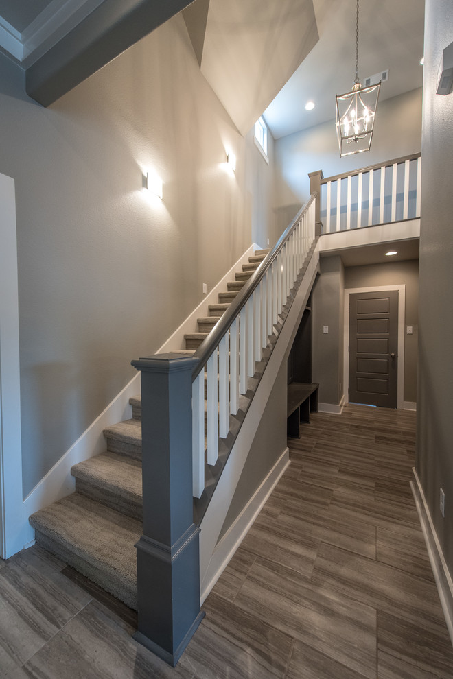 Пример оригинального дизайна: прямая лестница среднего размера в стиле кантри с ступенями с ковровым покрытием и ковровыми подступенками