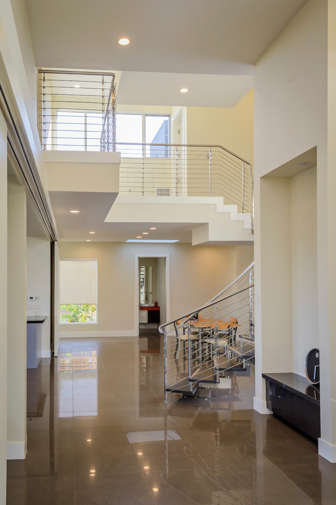Свежая идея для дизайна: изогнутая лестница среднего размера в стиле модернизм с деревянными ступенями и металлическими перилами без подступенок - отличное фото интерьера
