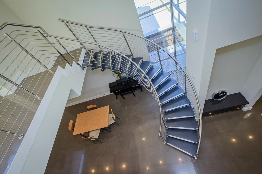 Inspiration for a mid-sized modern wooden curved open and metal railing staircase remodel in San Francisco