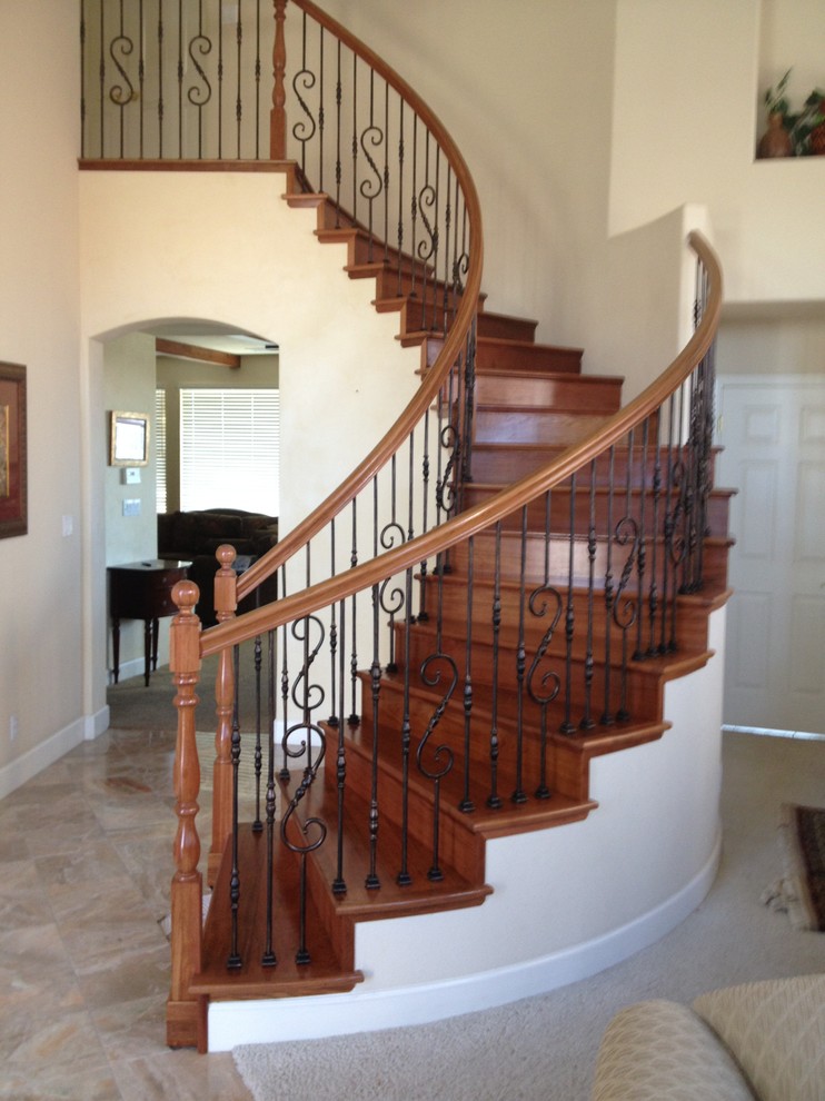 Large elegant wooden curved staircase photo in San Francisco with wooden risers