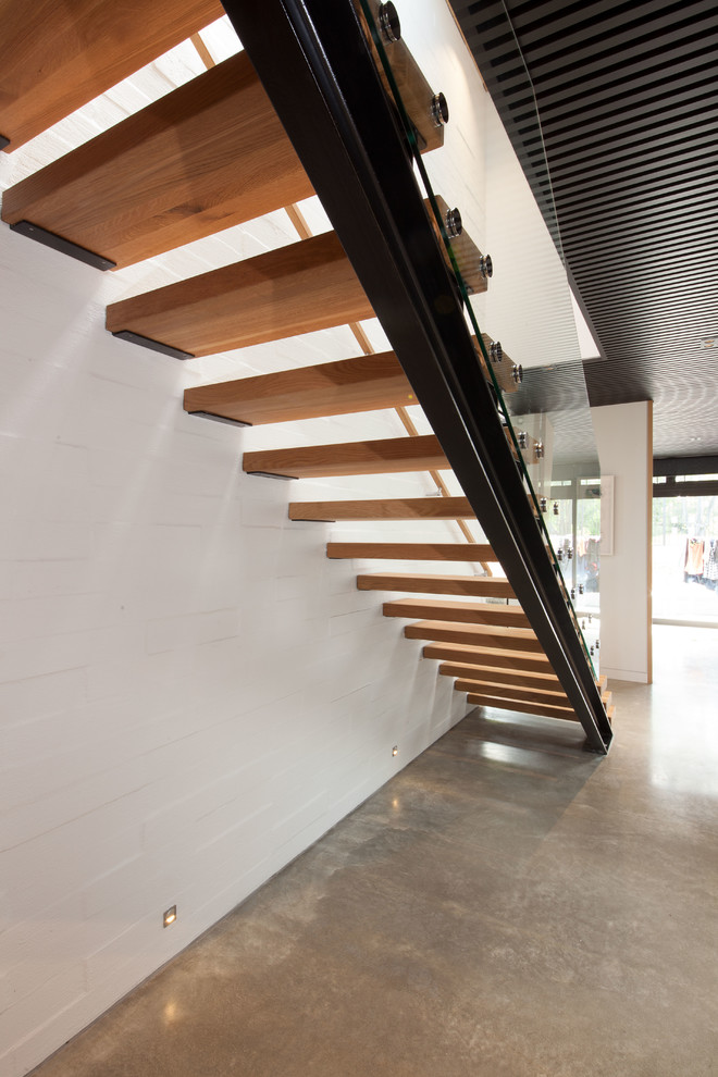 Foto de escalera recta urbana grande sin contrahuella con escalones de madera y barandilla de vidrio